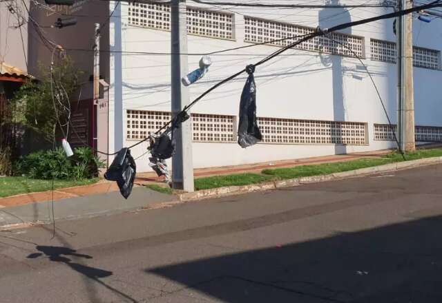 Moradores improvisam sinaliza&ccedil;&atilde;o com sacos amarrados em &quot;varal&quot; de fios ca&iacute;dos