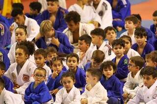 Judocas mirins sentados durante a abertura do evento (Foto: Henrique Kawaminami)