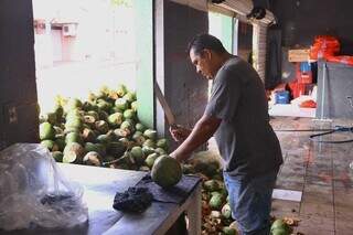 Funcionário do Aruba Cocos corta o fruto para clientes apreciarem a castanha (Foto: Paulo Francis)