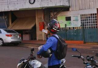 Motociclista toma água de coco em garrafa, na Rua Calarge, Vila Glória (Foto: Paulo Francis)