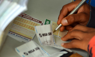 Apostador preenche volante de apostas da Mega-Sena em uma agência lotérica. (Foto: Marcelo Casal Jr./Agência Brasil)