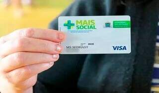 Mulher segura cartão do programa Mais Social (Foto: Divulgação)