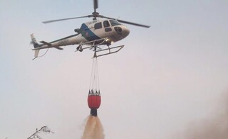Helicóptero equipado com bambi-bucket, uma cesto para despejar a água sobre as chamas. (Foto: Divulgação/Governo de MS)