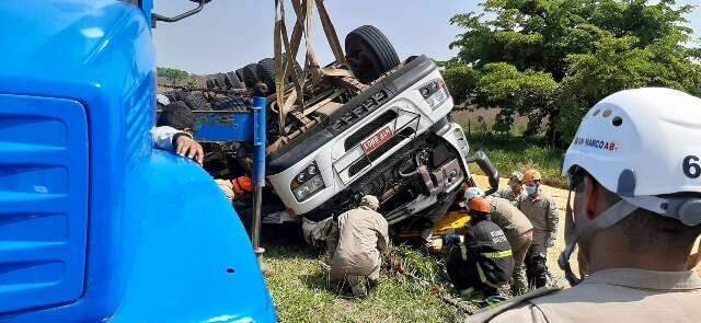 Carreta carregada de milho tomba e motorista fica preso &agrave;s ferragens na Capital