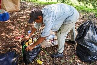 Otair junta latinhas em sacos de lixo para trocar por dinheiro. (Foto: Henrique Kawaminami)