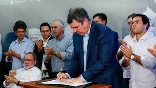 Governador Eduardo Riedel assinando o contrato de parcerias (Foto: Alex Machado)