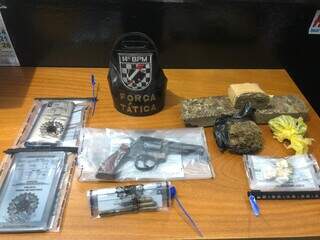 Arma, drogas e outros objetos apreendidos na casa. (Foto: Direto das Ruas)