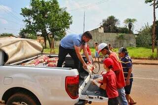 (De blusa azul), Luiz Fernando ajuda a descarregar doações para comunidade. (Foto: Paulo Francis)