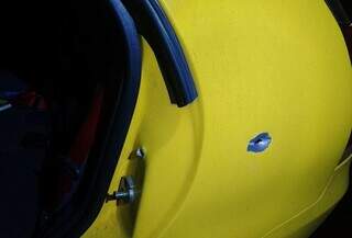 Disparo acertou lataria de veículo amarelo. (Foto: Reprodução/Dourados News)