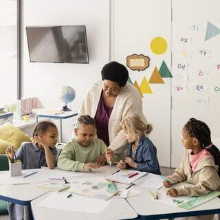 Professora na sala de aula ensina turma de crianças. (Foto: Freepik)