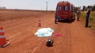 Corpo da vítima coberto sob lençol em estrada. (Foto: Rio Brilhante em Tempo Real)