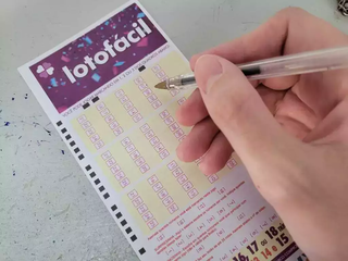 Apostador preenche volante de apostas da Lotofácil, em lotérica. (Foto: Arquivo)