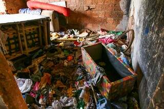 Interior da residência está cheio do de lixo, roupas, garafas e móveis danificados (Foto: Paulo Francis)