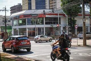 Carro e motocicleta parando em cima de cruzamento, no semáforo fechado (Foto: Henrique Kawaminami)