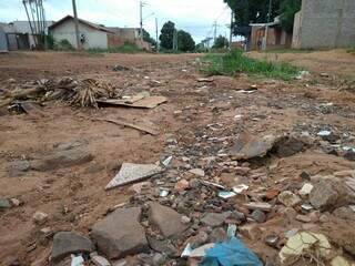 Na Rua Fidélis, moradores enchem valeta de pedras e restos de material de construção (Foto: Geniffer Valeriano)