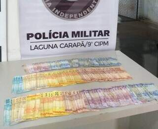 Dinheiro apreendido com homem flagrado dentro de casa lotérica (Foto: Divulgação/PM)