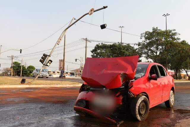 Motorista de aplicativo pega no sono, bate carro e derruba sem&aacute;foro de avenida 