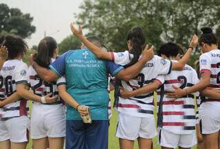 Jogadoras e técnico da Portuguesa fazendo oração antes de partida (Foto: Divulgação/Lusa)