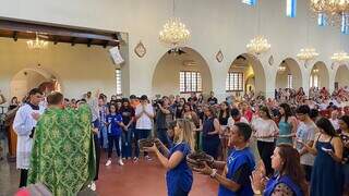 Sacerdote do Santuário Estadual Nossa Senhora do Perpetuo Socorro abençoa canetas e estudantes em missa (Foto: Antonio Bispo)