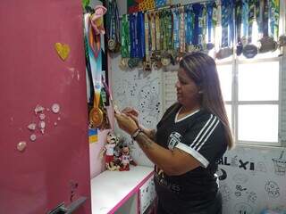 Jussara mostra as medalhas que a filha conquistou no esporte (Foto: Idaicy Solano)