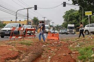 Pessoas atravessam o canteiro onde obra está paralisada (Foto: Henrique Kawaminami)