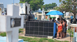 Para enfrentar o calor e o sol quente no Dia de Finadados, ontem em Corumbá, famílias tiveram que se proteger com guarda-sol (Foto: Anderson Gallo / Diário Corumbaense) 