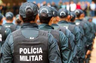 Duas policiais militares de cabelo preso entre fileiras de maioria masculina (Foto: Arquivo/Henrique Kawaminami)