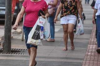 Consumidores com sacolas de compras, na Rua 14 de Julho (Foto: Marcos Maluf)