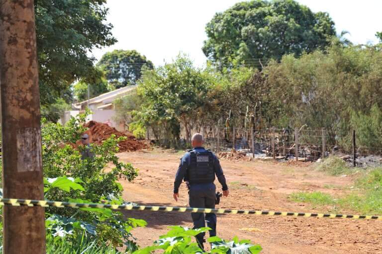 Policial militar dentro de trecho da rua que foi isolado após achado de cadáver (Foto: Paulo Francis)