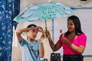 Yasmin e a professora Michelly junto ao guarda-chuva literário (Foto: Divulgação)