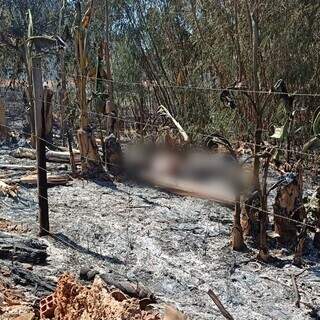 Cadáver de homem perto da cerca do terreno após incêndio ser controlado (Foto: Direto das Ruas)