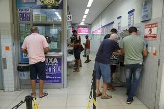 Clientes de lotérica da Capital realizando aposta na loteria (Foto: Henrique Kawaminami)