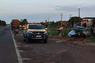 Pessoas recolhendo a droga espalhada na MS-145 e Fiat Strada destruído (Foto: Direto das Ruas)