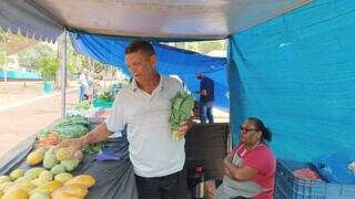 Edson, morador de Ribas de Rio Pardo, mostrando os produtos durante a feira (Foto: Viviane Oliveira) 