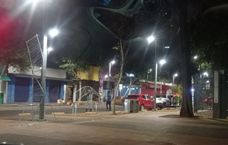 Homens colocaram os painéis que sustentam as mangueiras iluminadas na Rua 14 de Julho, na noite de quarta-feira (14). (Foto: Gabriela Couto)
