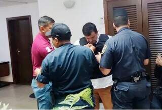 Policiais colocam colete à prova de bala em pastor, logo após ele se entregar em Asunción (Foto: ABC Color)