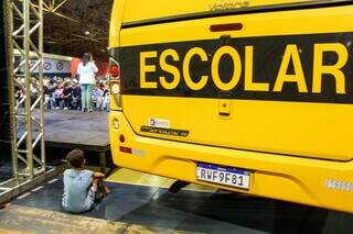 Aluno da rede municipal acompanha anúncio de ações pela prefeita Adriane Lopes sentado atrás de novo ônibus escolar. (Foto: Juliano Almeida)