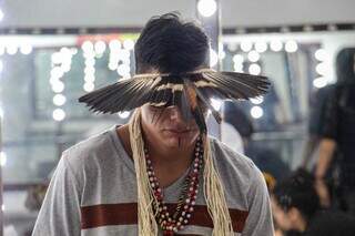 Com cocar e colares tradicionais, o rapper CH aguarda apresentação no teatro Glauce Rocha (Foto: Juliano Almeida)