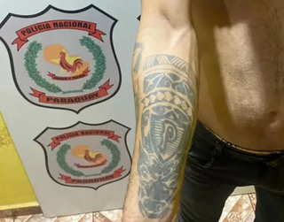 Rapaz mostra a tatuagem em delegacia da Polícia Nacional (Foto: Divulgação) 