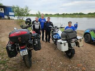 De camiseta azul entre os dois motociclistas, o secretário de Estado de Meio Ambiente, Desenvolvimento, Ciência, Tecnologia e Inovação, Jaime Verruck acompanha passagem do comboio sobre o Rio Paraguai neste sábado (Foto: Divulgação)