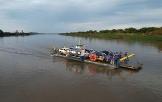 Caminhonetes atravessando, de balsa, trecho do Rio Paraguai até Loma Plata. (Foto: Paulo Cruz)