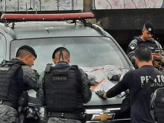 Policiais do Choque e perito com material apreendido com quadrilha (Foto: Geniffer Valeriano)