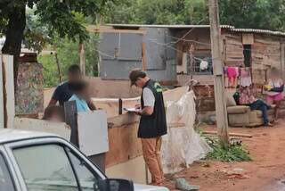 Fiscal da prefeitura entrega notificação a moradora na comunidade (Foto: Paulo Francis)