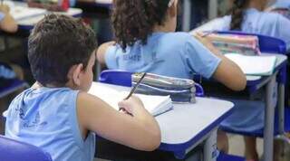 Estudante da Rede Municipal de Ensino de Campo Grande, anotando em caderno na sala de aula (Foto: Semed)