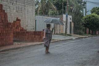 Mulher se protegendo com guarda-chuva na manhã desta segunda-feira (4) (Foto: Marcos Maluf)