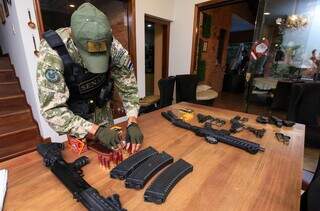 Agente da Senad separa armas e munições apreendidas em operação (Foto: Divulgação)