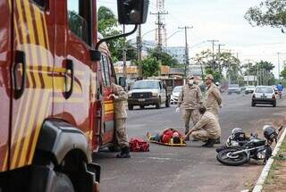 Militares dos bombeiros durante socorro às vítimas e moto caída. (Foto: Henrique Kawaminami)