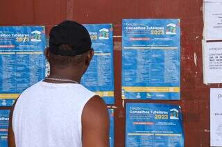 Eleitor confere lista de candidatos a conselheiros tutelares nas eleições de outubro. (Foto: Henrique Kawaminami/Arquivo)