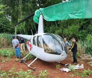 Policiais paraguaios ao lado do helicóptero, encontrado em mata na fronteira (Foto: ABC Color)