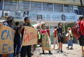 Cerca de 20 manifestantes ocupam a frente do paço municipal, no Centro de Campo Grande (Foto: Henrique Kawaminami)